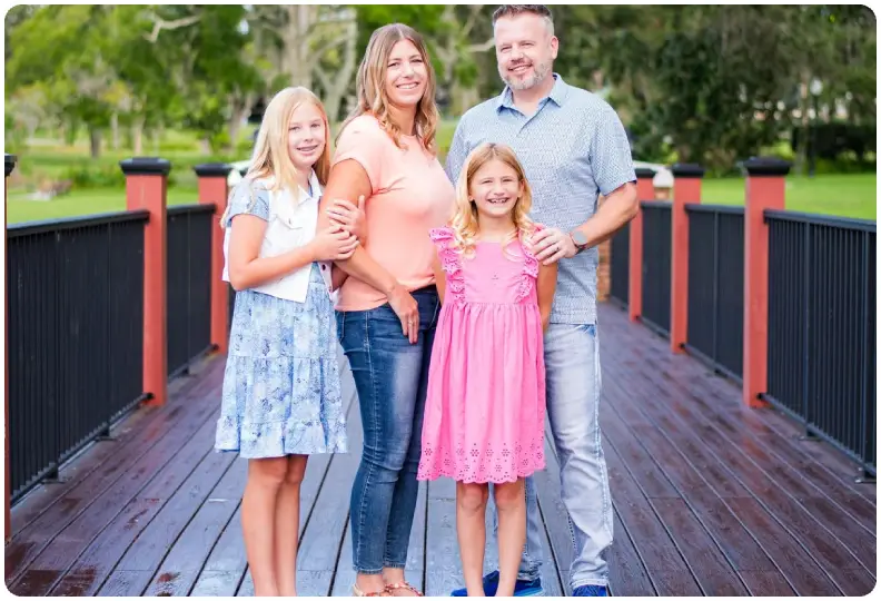 A family posing for a picture on the bridge.