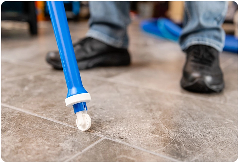 A person is standing on the floor with a blue object.